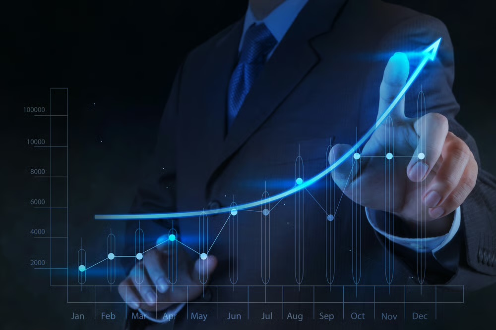 Businessman pointing at a glowing chart with an upward growth arrow