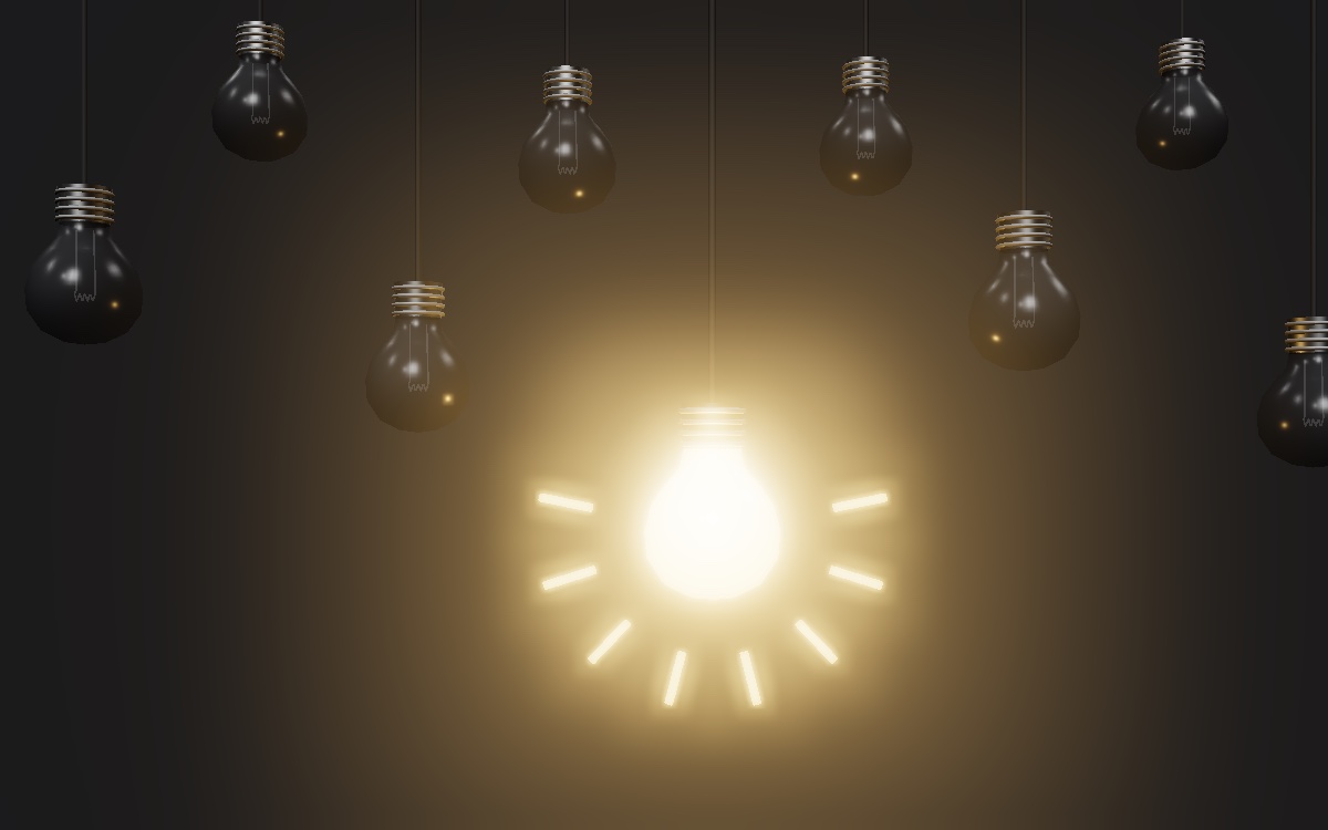 Row of dark hanging light bulbs with one bulb glowing: a symbol of creative ideas
